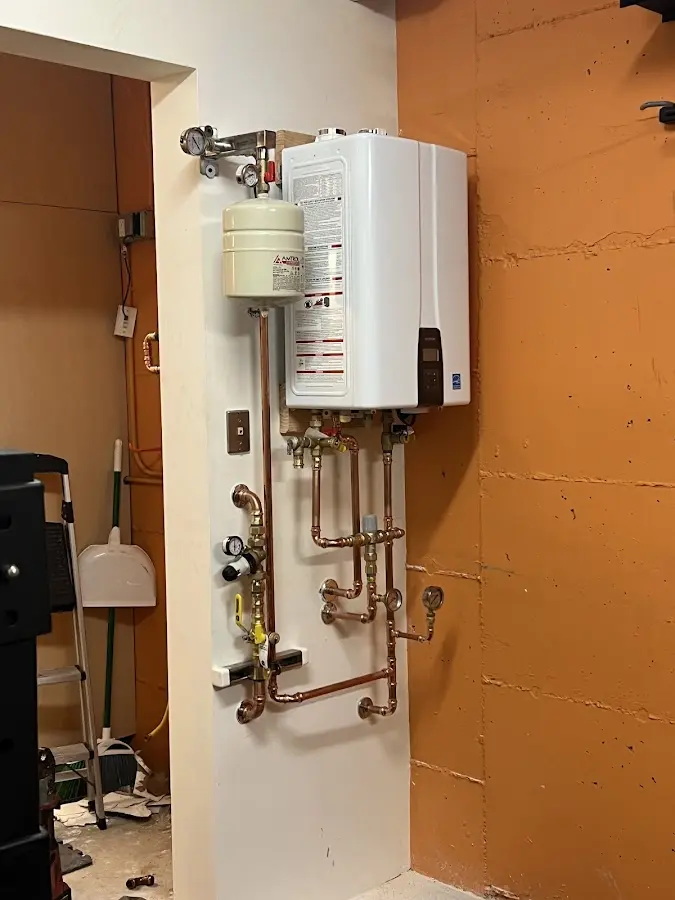 Plumbing technician inspecting water heater connections in East Port Orchard